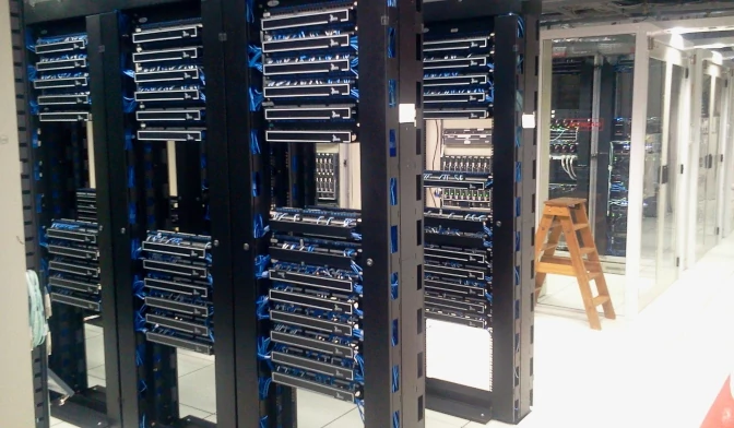 Bild von einem Rechenzentrum mit einer Trittleiter hinter mehreren Server-Racks